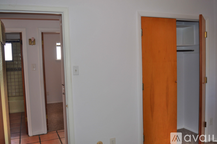 A room with a white wall and a brown door.