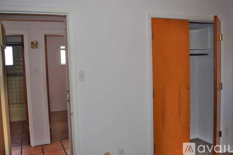 A room with a white wall and a brown door.