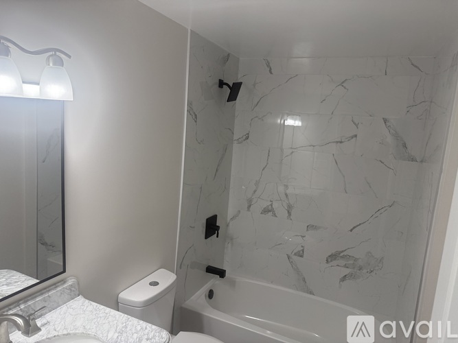 A bathroom with a marble wall and a bathtub.