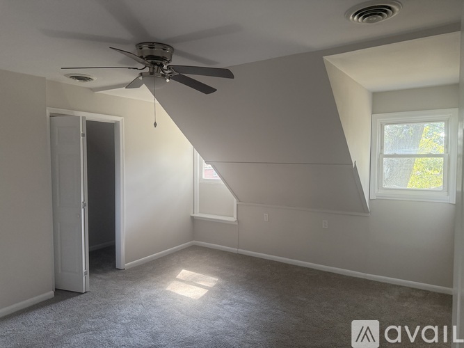 A room with a ceiling fan and a window.