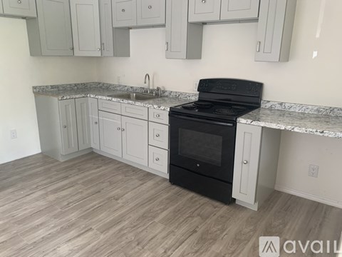 A kitchen with a black oven and white cabinets.
