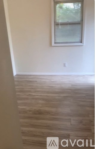 A room with a window and wooden flooring.