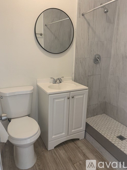 A bathroom with a toilet, sink, and shower.
