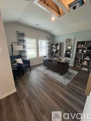 A living room with a blue chair and a wooden floor.