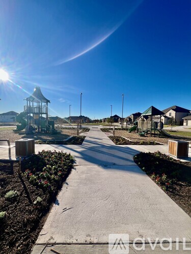 A sunny day in a park with a playground and a gazebo.