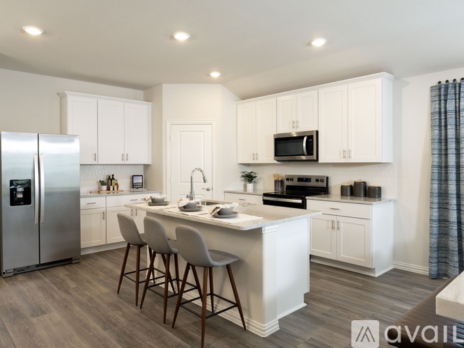 A kitchen with white cabinets and a wooden island.