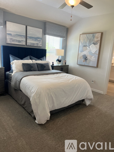 A bedroom with a large bed and a ceiling fan.