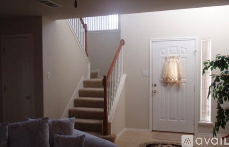A living room with a couch and a staircase.