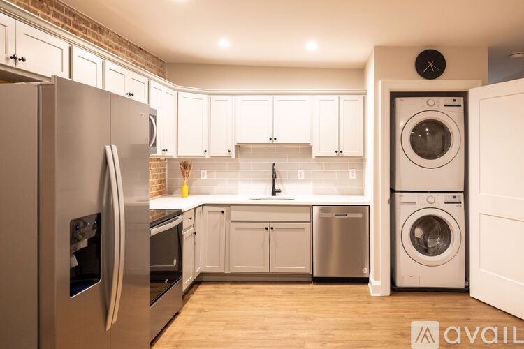 A modern kitchen with a refrigerator, oven, and washing machine.