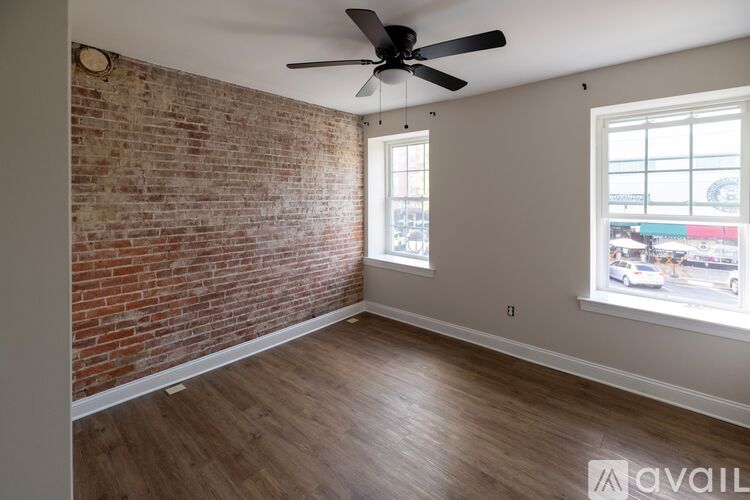 A room with a brick wall and a ceiling fan.