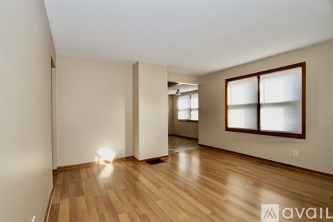 A room with wooden floors and a window with blinds.
