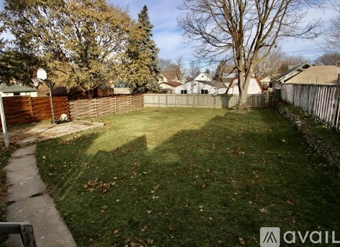 A backyard with a fence and trees.