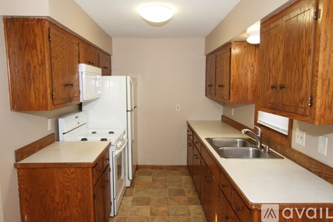 A kitchen with wooden cabinets and white appliances.