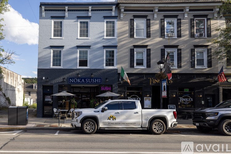 A white truck is parked in front of a building with a sign that says "NOKA SUSHI".