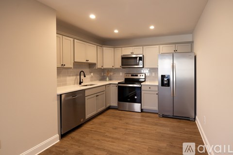 A kitchen with stainless steel appliances and wooden floors.