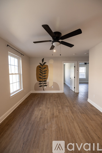 A room with a ceiling fan and a wooden floor.