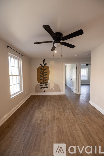 A room with a ceiling fan and a wooden floor.