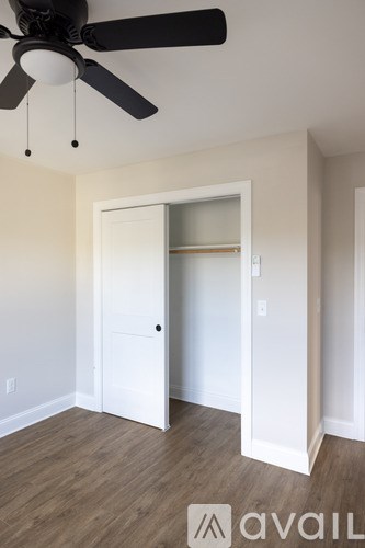 A room with a ceiling fan and a door.