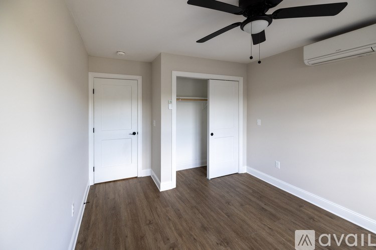 A room with a ceiling fan and two doors.