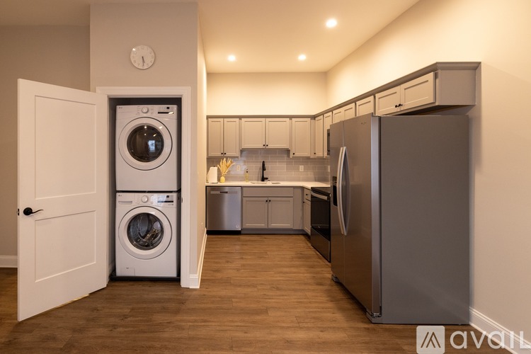 A modern kitchen with a washer and dryer built into the cabinetry.