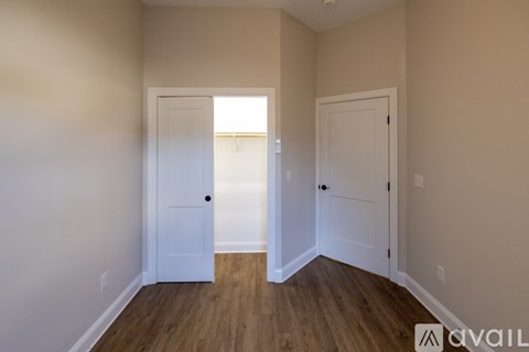 A room with two doors and wooden floors.