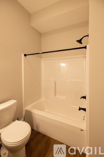 A white toilet sits next to a white bathtub in a bathroom.