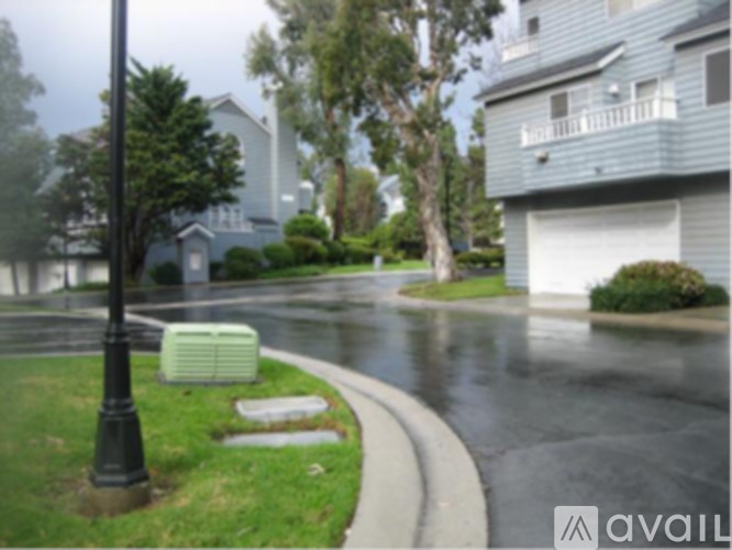 A street with a lamp post and a house in the background.