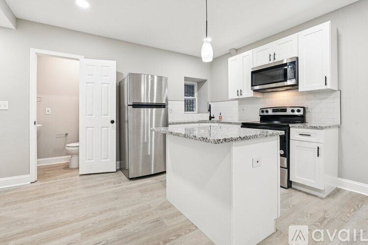 A kitchen with white cabinets and a stainless steel refrigerator.