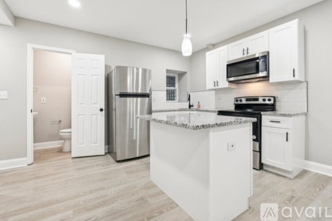 A kitchen with white cabinets and a stainless steel refrigerator.