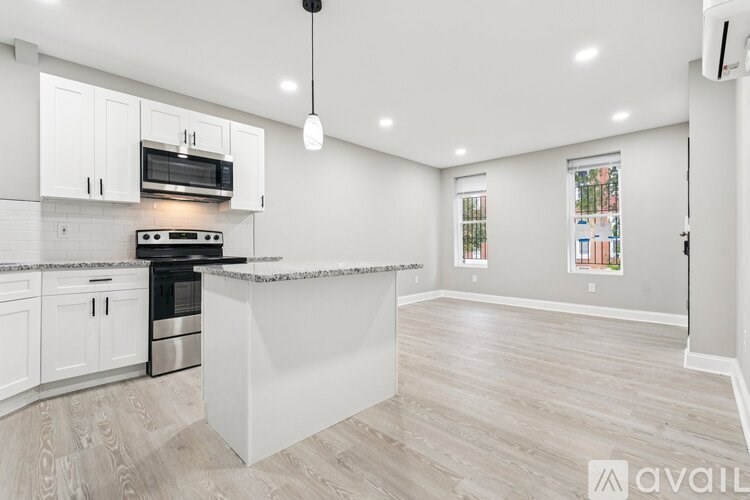 A modern kitchen with a marble countertop and stainless steel appliances.