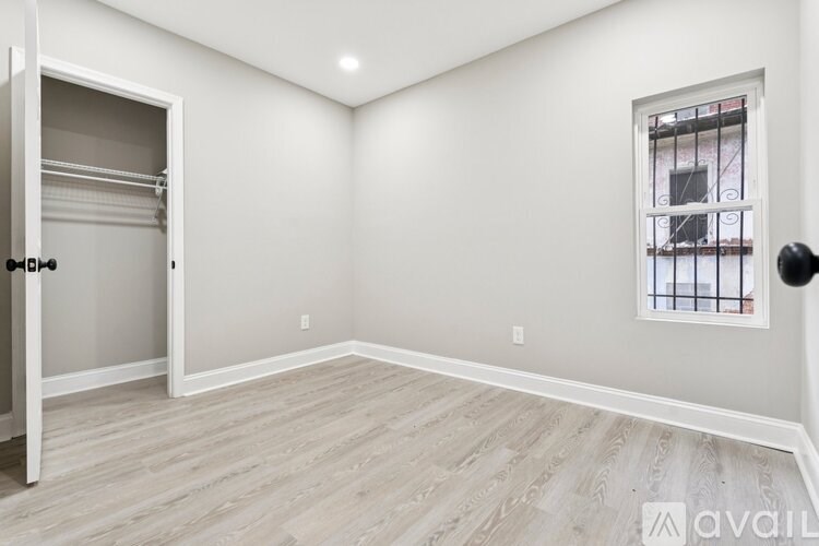 A room with a sliding door and a window with bars.