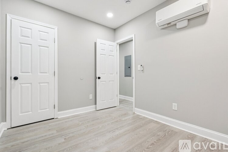 A room with a white door, a white wall, and a white ceiling.