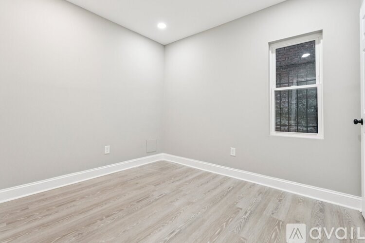 A room with a window and wooden flooring.