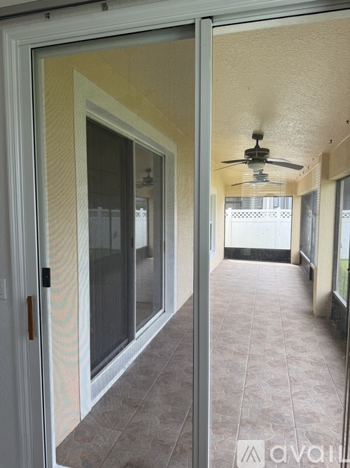 A small refrigerator is installed in a narrow space between a door and a wall.