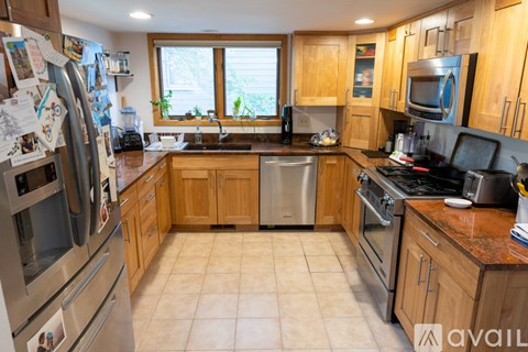 A kitchen with wooden cabinets and a tiled floor.