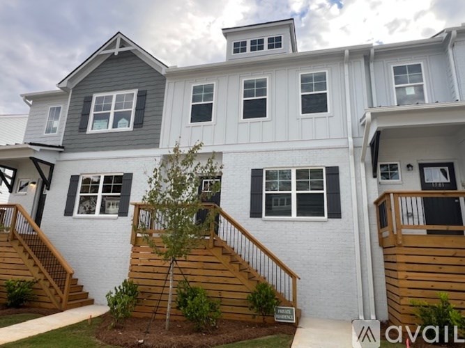 A two-story house with a grey roof and white walls.