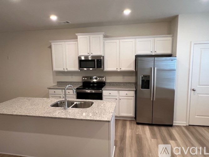 A kitchen with white cabinets and a granite countertop.