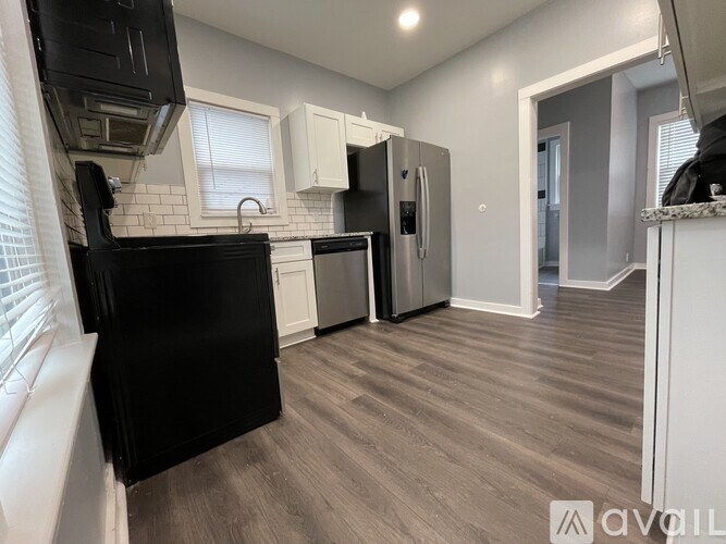 A kitchen with black appliances and white cabinets.