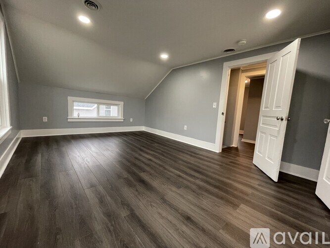 A room with wooden flooring and a window.