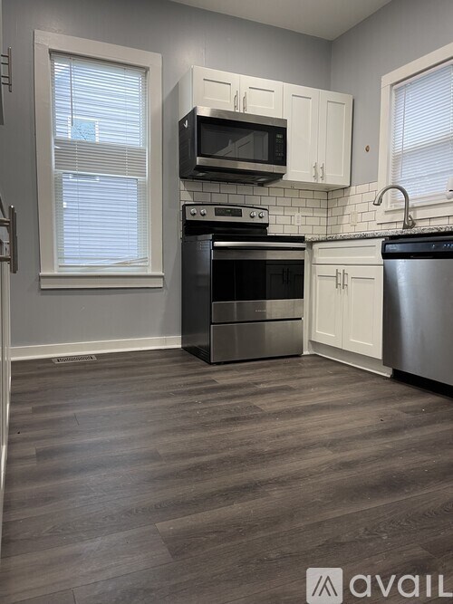 A kitchen with a stove, oven, and microwave.