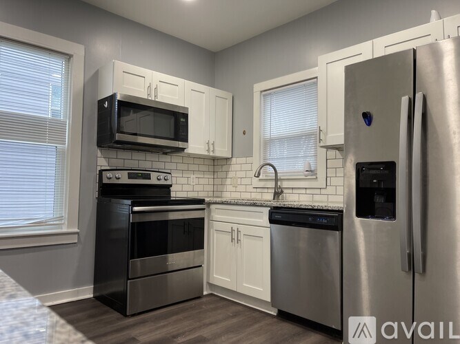A kitchen with a stainless steel refrigerator, microwave, oven, and dishwasher.