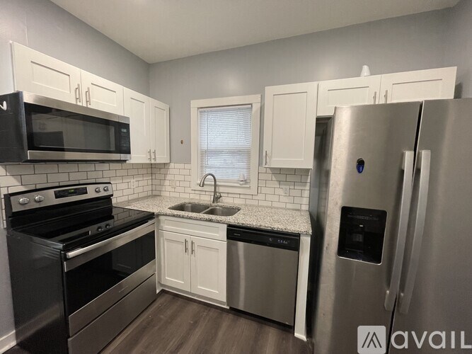 A kitchen with a black microwave, stove, and refrigerator.