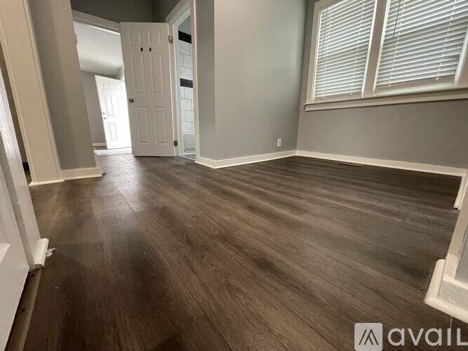 A room with wooden flooring and a white door.