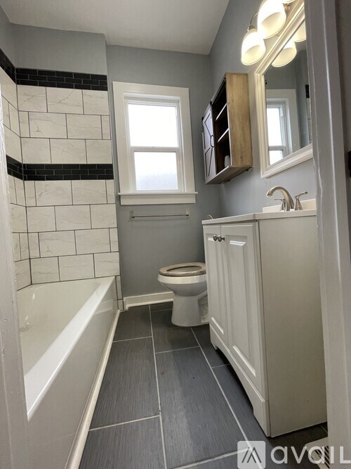A bathroom with a white tub and a toilet.