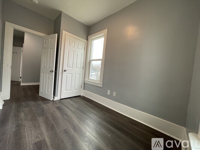 A room with a wooden floor and two white doors.