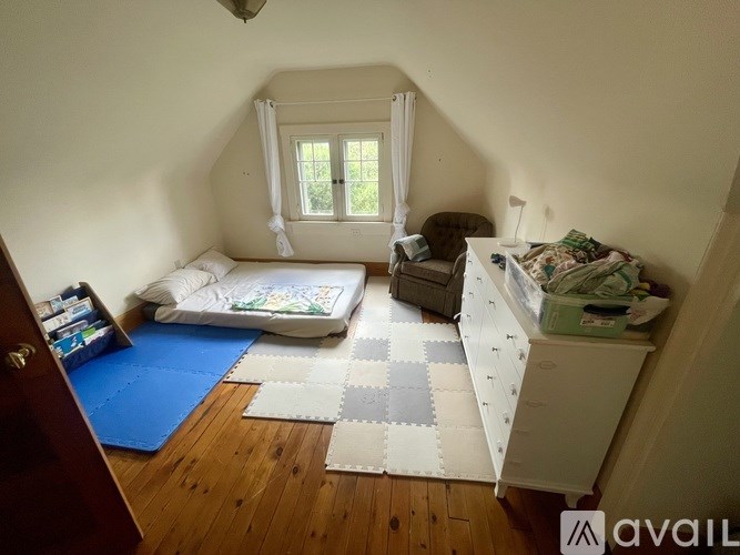 A room with a bed, a chair, and a dresser.