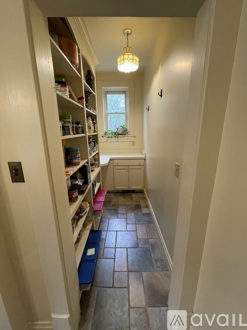 A hallway with a pink container on the floor.