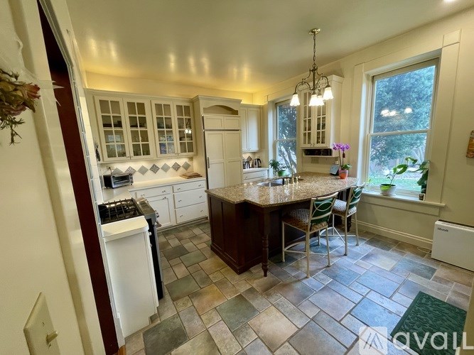 A kitchen with a tiled floor and a large island in the middle.