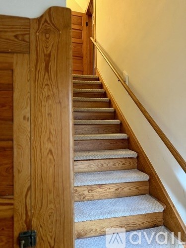 A wooden staircase with a carpeted runner.
