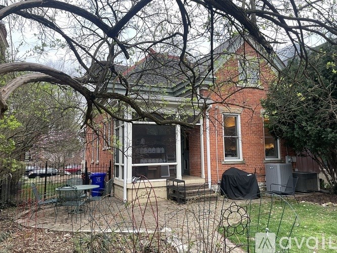 A house with a red brick exterior and a porch covered by a black tarp.
